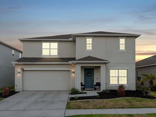 555 Meadow Bend Dr, Davenport, FL 33837 - traditional home with stucco siding, an attached garage, and concrete driveway