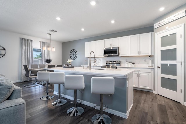 555 Meadow Bend Dr, Davenport, FL 33837 - kitchen featuring appliances with stainless steel finishes, a sink, light countertops, a breakfast bar, and recessed lighting