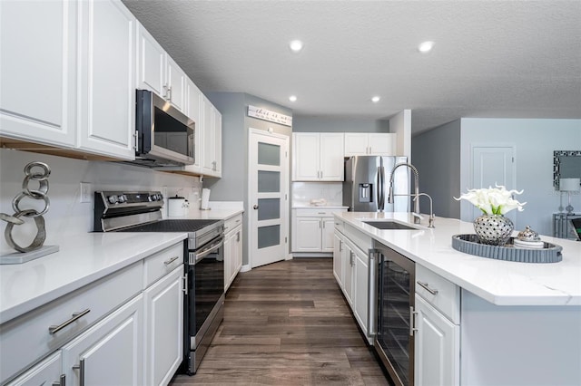 555 Meadow Bend Dr, Davenport, FL 33837 - kitchen featuring stainless steel appliances, beverage cooler, dark wood-style floors, white cabinetry, and recessed lighting