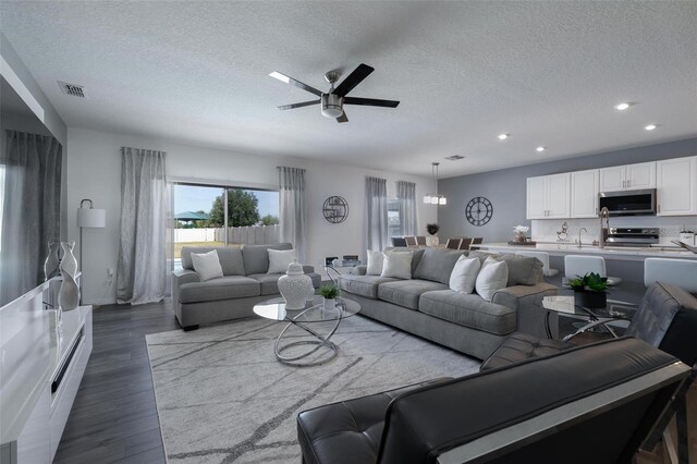 555 Meadow Bend Dr, Davenport, FL 33837 - living area with a textured ceiling, ceiling fan, recessed lighting, and dark wood finished floors