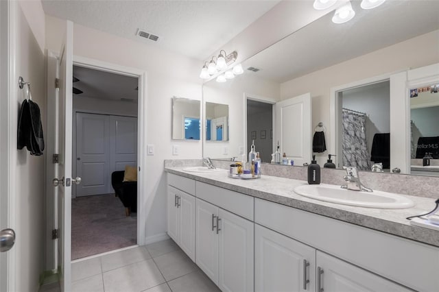 555 Meadow Bend Dr, Davenport, FL 33837 - ensuite bathroom featuring tile patterned flooring, double vanity, and baseboards