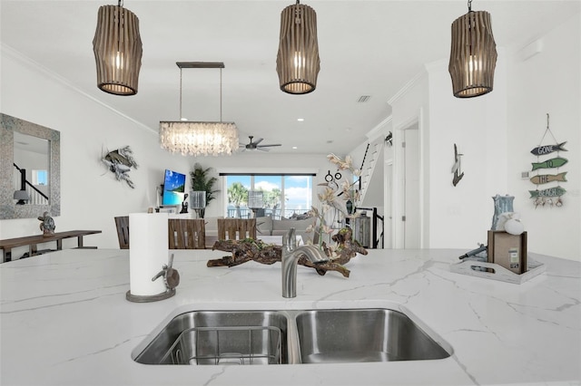 7 Marden Dr, Ormond Beach, FL 32176 - kitchen featuring a sink, light stone counters, decorative light fixtures, ornamental molding, and a chandelier