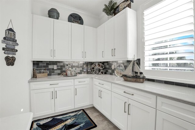 7 Marden Dr, Ormond Beach, FL 32176 - kitchen with backsplash, ornamental molding, white cabinets, and light countertops
