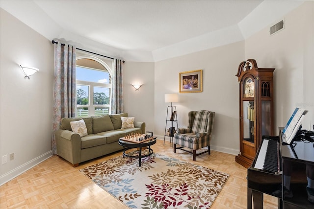 living area featuring baseboards and visible vents