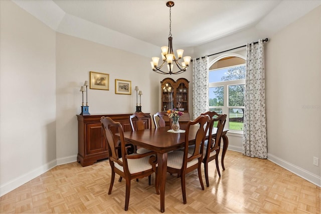 dining space with baseboards and a chandelier