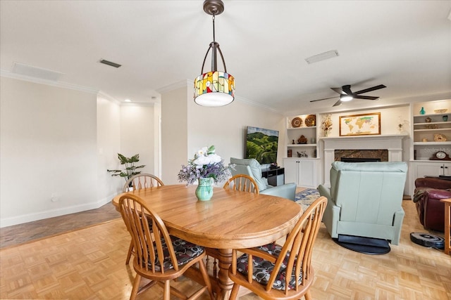 dining area with visible vents, ornamental molding, ceiling fan, and a fireplace