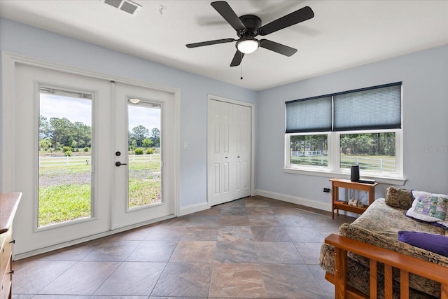 interior space featuring visible vents, baseboards, ceiling fan, french doors, and stone finish flooring