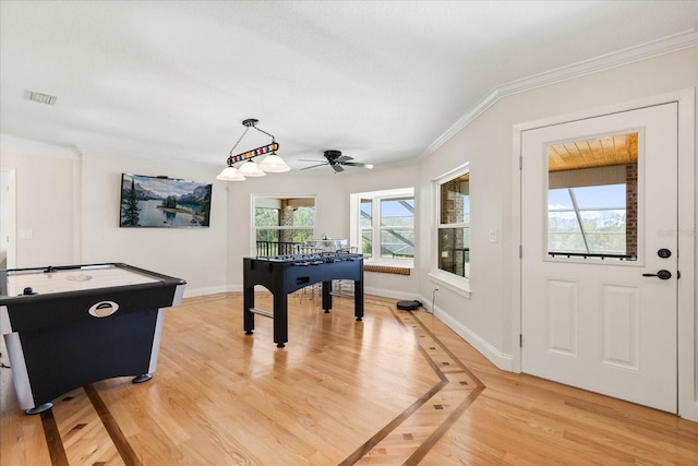 game room with crown molding, baseboards, ceiling fan, and light wood-style flooring
