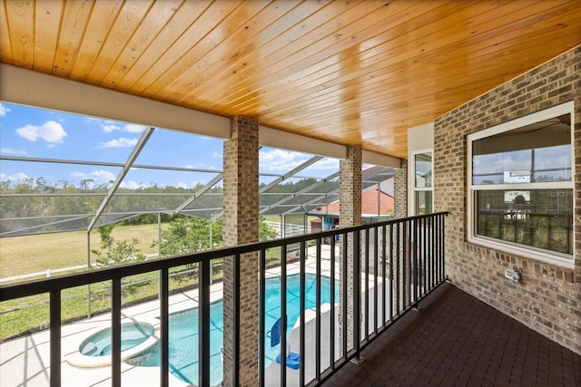 balcony featuring a pool with connected hot tub