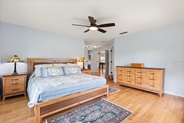 bedroom featuring a ceiling fan, visible vents, and light wood-style floors