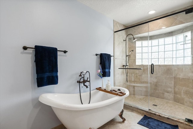 bathroom featuring a freestanding tub, a shower stall, tile patterned floors, and a textured ceiling