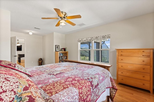 bedroom featuring ceiling fan, wood finished floors, and visible vents