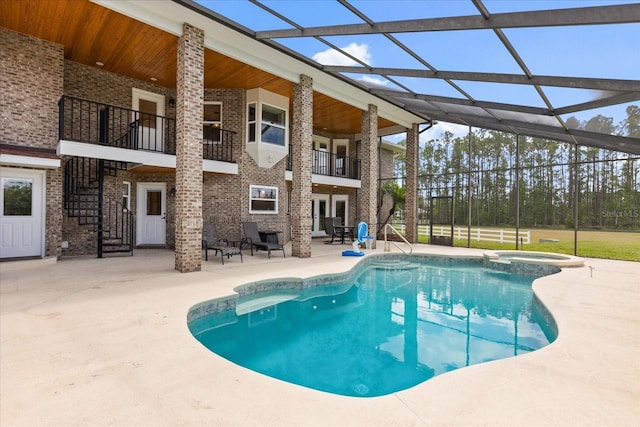view of pool with a patio, stairway, a lanai, and a pool with connected hot tub