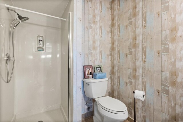 full bathroom featuring a stall shower and toilet