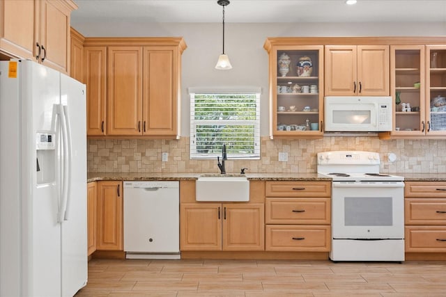 kitchen with a sink, light wood-style flooring, decorative backsplash, and white appliances