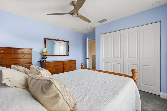 carpeted bedroom featuring a ceiling fan, visible vents, attic access, and a closet