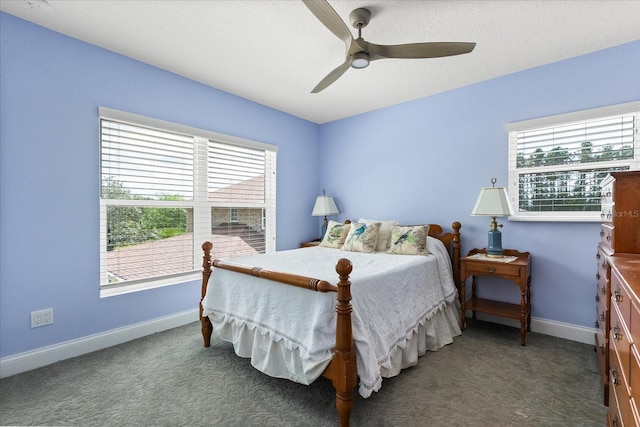 carpeted bedroom featuring a ceiling fan, baseboards, and multiple windows