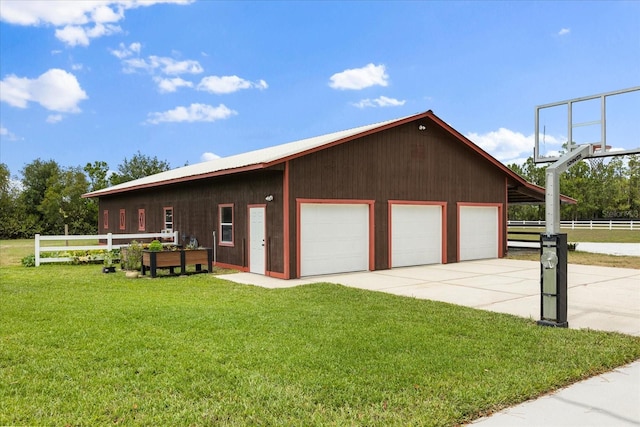 exterior space featuring fence, a detached garage, and driveway