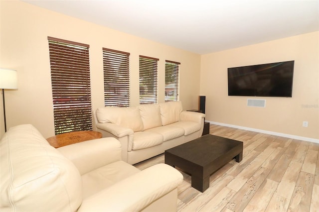living area with light wood-type flooring and baseboards