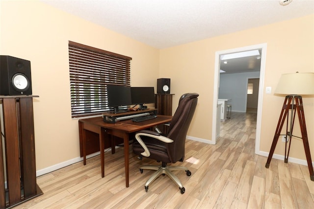 office featuring baseboards and light wood finished floors