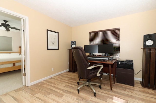 office featuring baseboards, light wood-style flooring, and ceiling fan