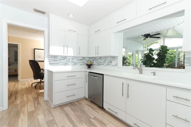kitchen featuring a sink, light countertops, tasteful backsplash, stainless steel dishwasher, and visible vents