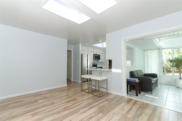 living room featuring baseboards and light wood-type flooring