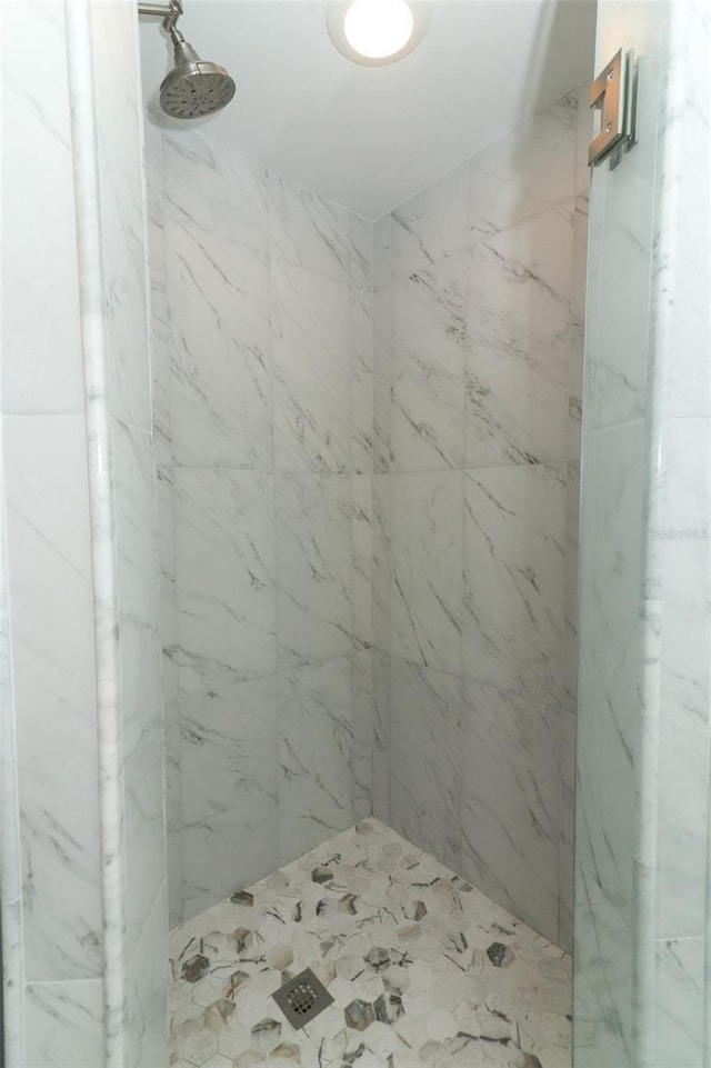 full bath featuring a marble finish shower