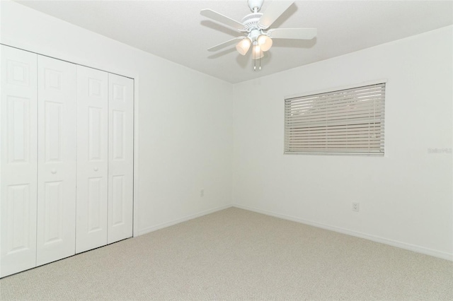 unfurnished bedroom featuring carpet flooring, baseboards, ceiling fan, and a closet