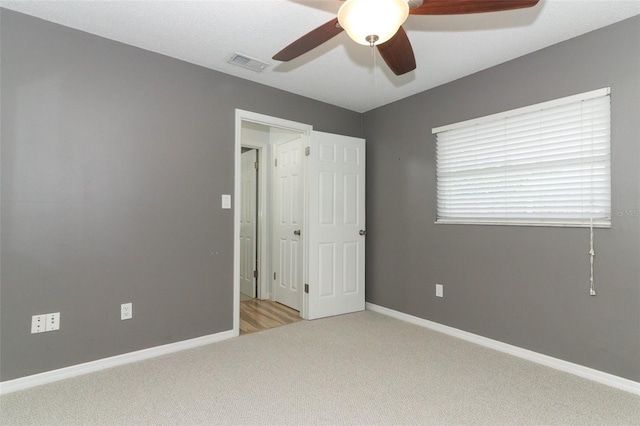 unfurnished bedroom with baseboards, ceiling fan, carpet, and visible vents