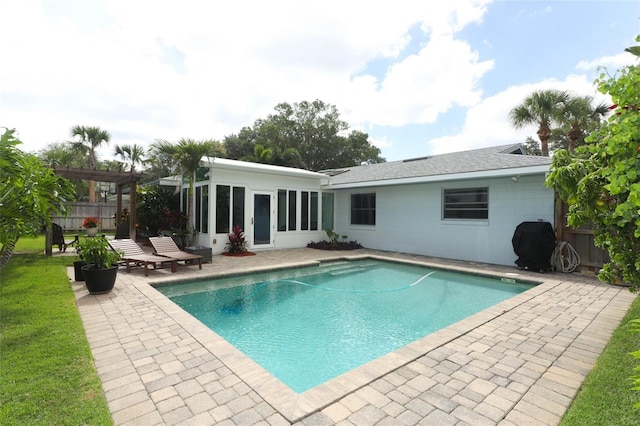 view of pool featuring a patio, a fenced in pool, fence, and a sunroom