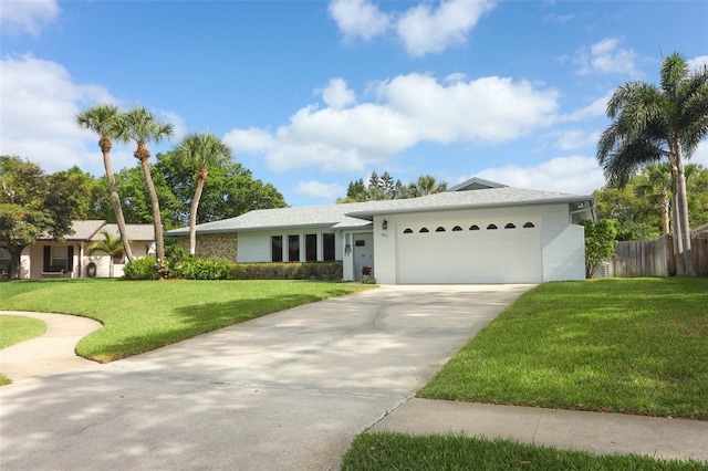 ranch-style house with an attached garage, a front lawn, fence, and driveway