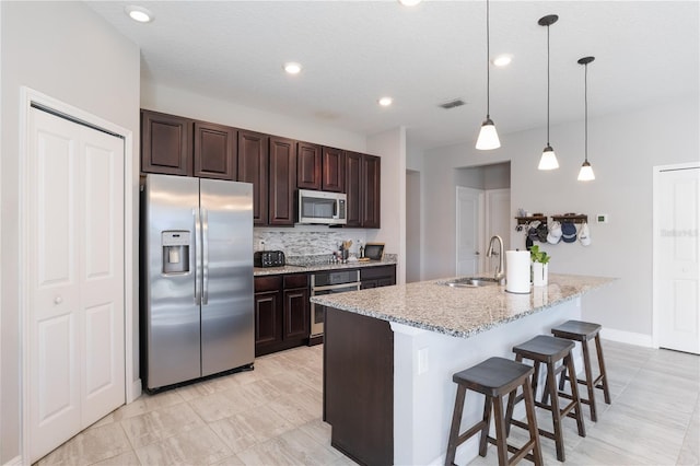 kitchen with decorative backsplash, dark brown cabinetry, visible vents, a sink, and stainless steel appliances
