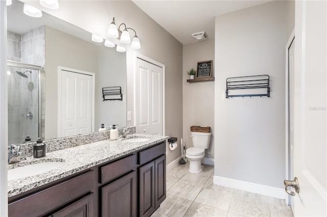 full bath with double vanity, a sink, toilet, and a shower stall