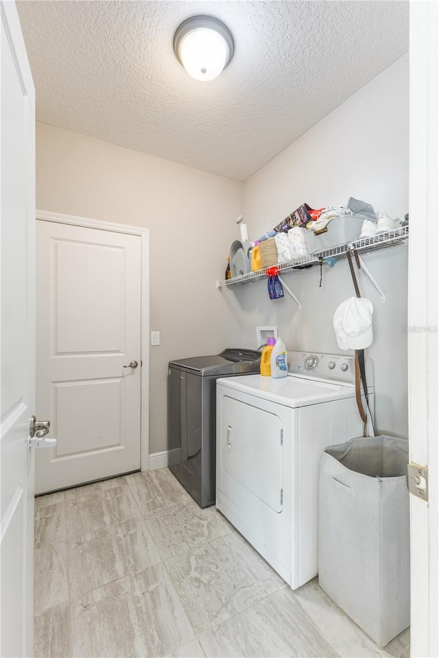 laundry area featuring laundry area, a textured ceiling, baseboards, marble finish floor, and separate washer and dryer