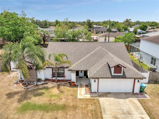 single story home featuring driveway, a residential view, an attached garage, a shingled roof, and stucco siding