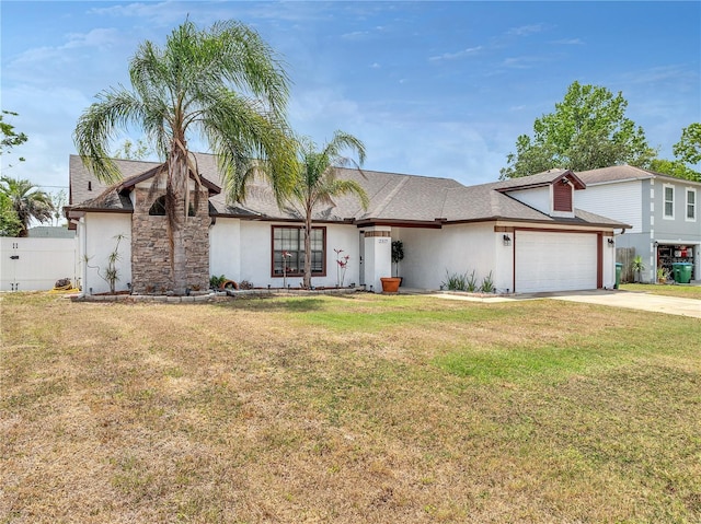 view of front of property featuring an attached garage, a front lawn, stucco siding, and driveway
