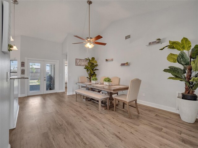 dining space featuring ceiling fan, high vaulted ceiling, baseboards, light wood-type flooring, and visible vents
