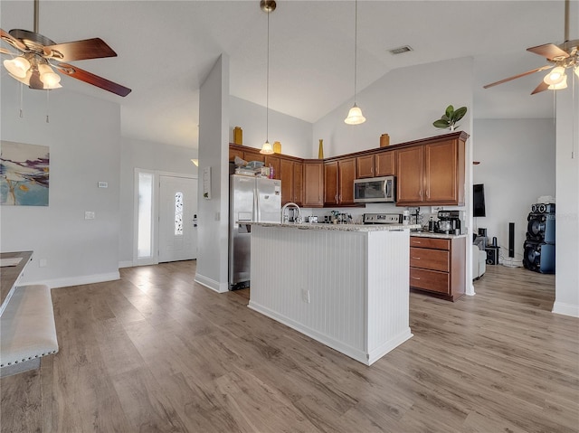 kitchen with ceiling fan, appliances with stainless steel finishes, high vaulted ceiling, light wood-type flooring, and visible vents