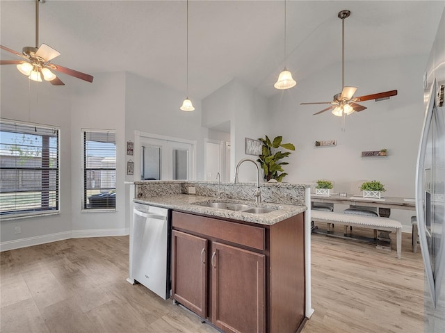kitchen featuring stainless steel appliances, a ceiling fan, a sink, and high vaulted ceiling