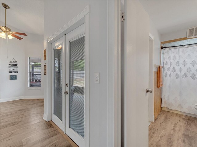 hall featuring french doors, light wood-style flooring, baseboards, and visible vents