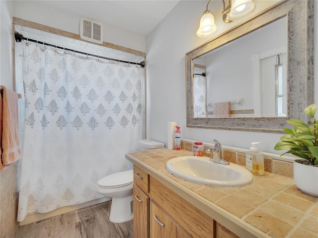 bathroom featuring visible vents, wood finished floors, curtained shower, vanity, and toilet