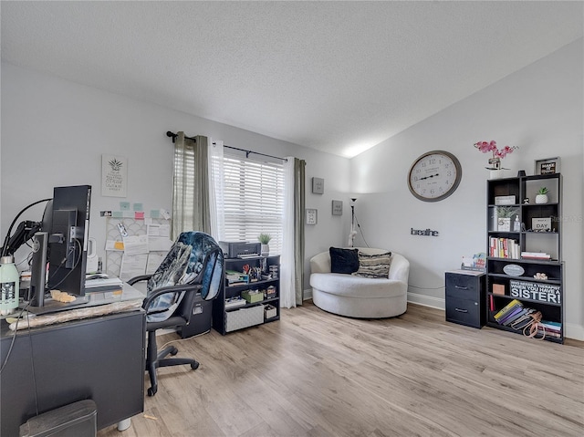 office area with a textured ceiling, vaulted ceiling, and wood finished floors