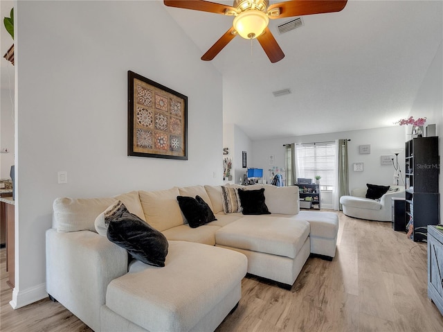 living room with high vaulted ceiling, a ceiling fan, light wood-style flooring, and visible vents