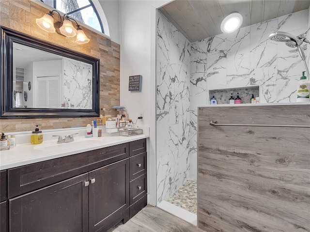 full bathroom featuring a marble finish shower and vanity