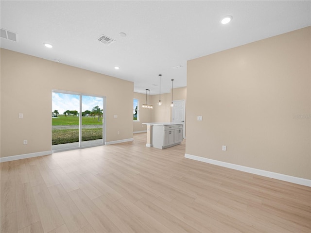 unfurnished living room featuring baseboards, recessed lighting, light wood-style flooring, and visible vents