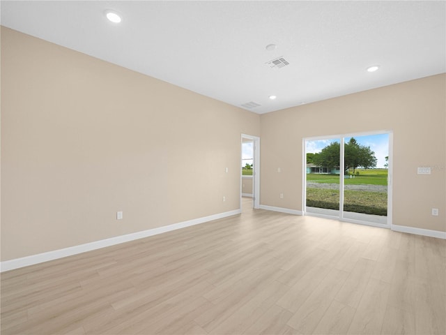 unfurnished room with light wood-style flooring, baseboards, visible vents, and recessed lighting
