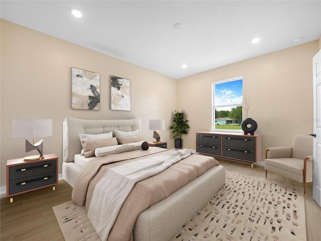 bedroom featuring baseboards, light wood-type flooring, and recessed lighting