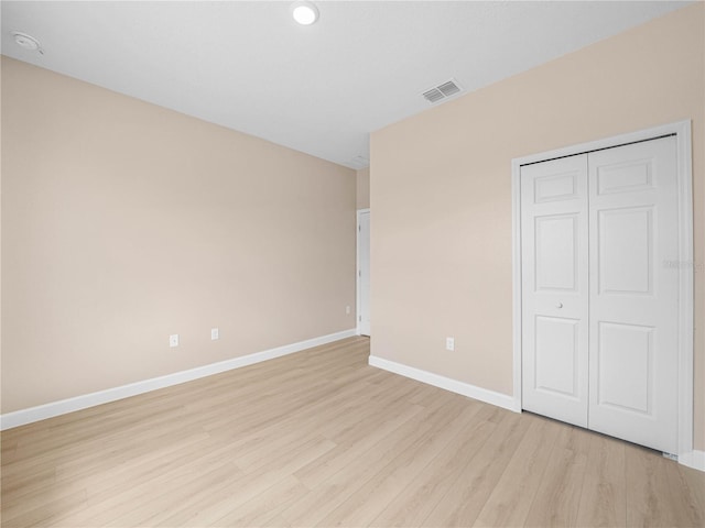unfurnished bedroom featuring light wood-style flooring, baseboards, a closet, and recessed lighting