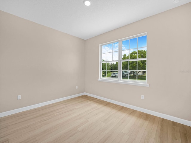 empty room with baseboards and light wood-style floors